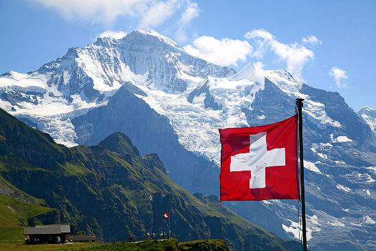 Swiss flag with mountains in the background