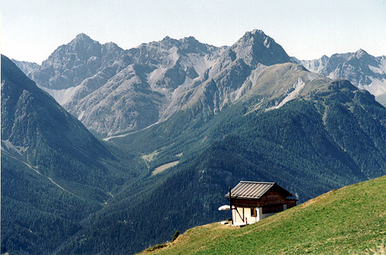 house on side of hill with mountains in the background, Graubunden, Switzerland