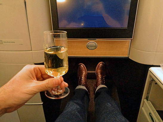 a glass of champagne at the writer's business class seat