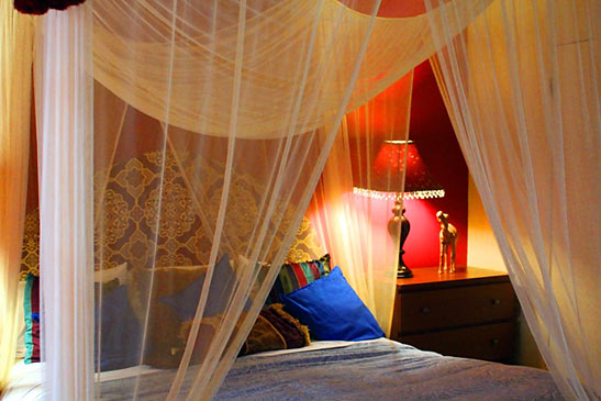 room inside the El Morocco Inn and Spa showing bed draped with canopy net