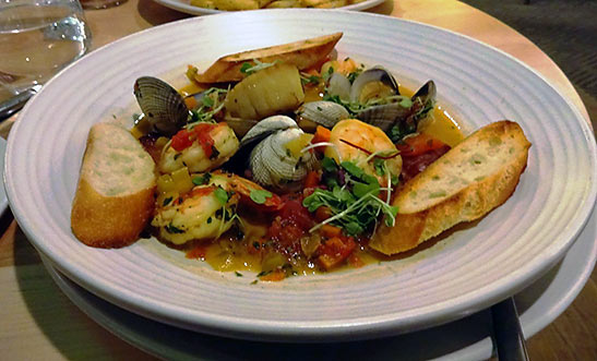 seafood hot pot with Pacific white shrimp, clams, scallops, and sausage in a saffron broth
