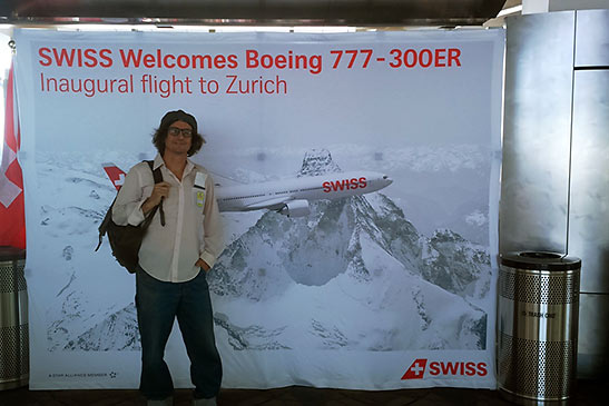 writer with SWISS Air welcome sign