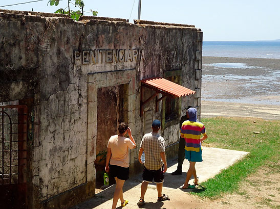 writer and his companions walk by old and abandoned prison cell, Isla Coiba, Panama