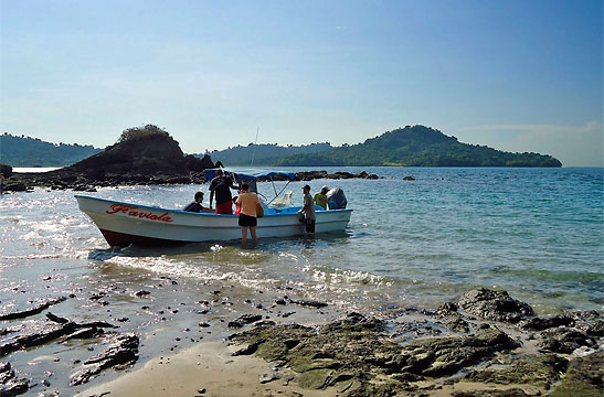 writer's group on boat at a beach in Coiba Island, Panama