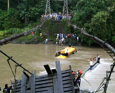 view of collapsed bridge and bus wreck in river near Orotino