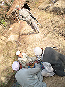 Afghans preparing for a meal with US Army solider nearby