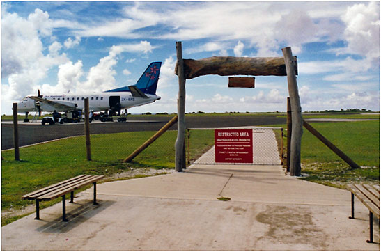 the arrival area at Aitutaki International Airport with a Saab 340 passenger liner in the background