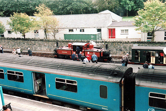 in the background: old, small train on display; in the foreground: modern, operational train (the Arriva)