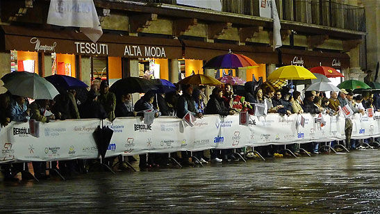 umbrella-covered Vicenza residents lined up on the route of Mille Miglia under a falling rain