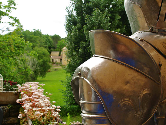 medieval armor with Dordogne River valley village in the background