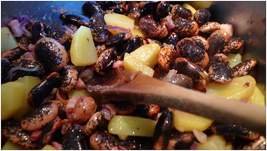 beans added to bacon cubes, potatoes and onions