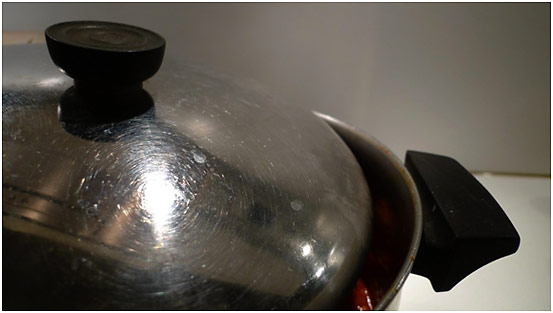 partially covered cooking pot on stove