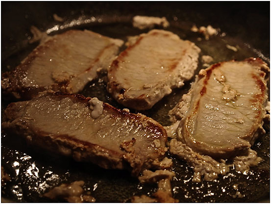 pork loin chops cooking in skillet