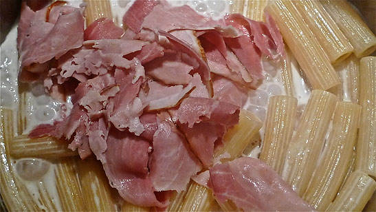 pieces of ham added to pasta, cheese and cream