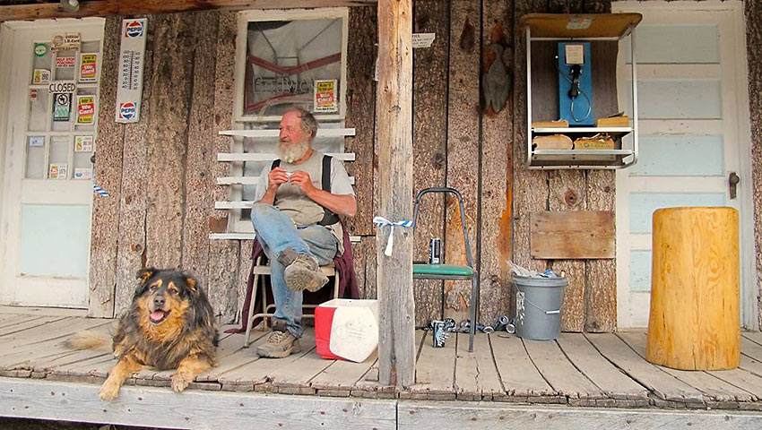 man and his dog at a storefront porch