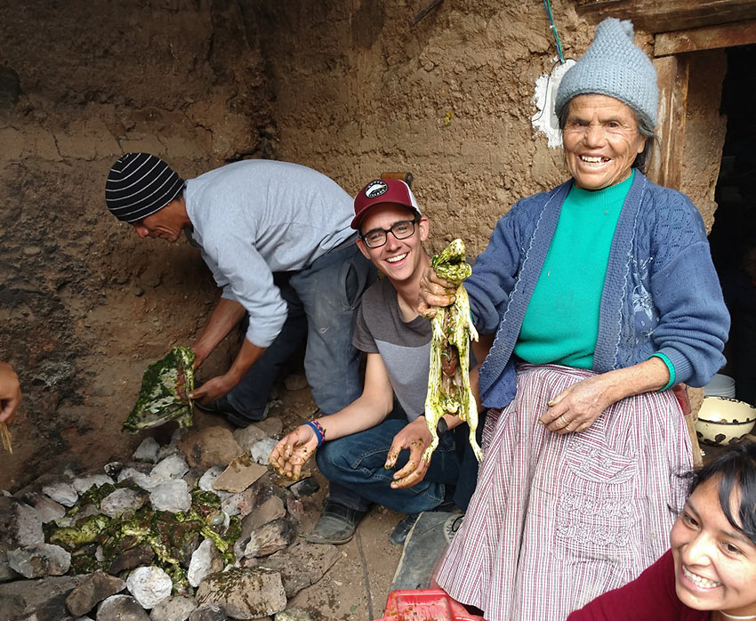 writer helping prepare food with locals