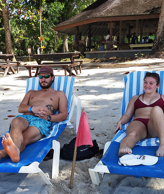 couple with red flag at a beach in in Negril, Jamaica