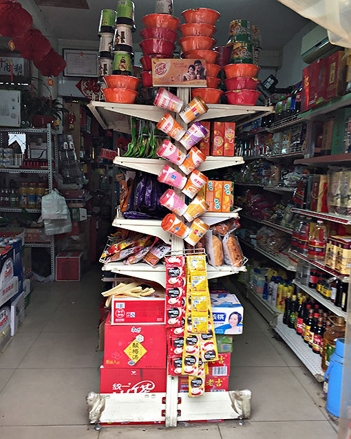 a variety of convenience foods and just-add-water items on the shelves of a small store