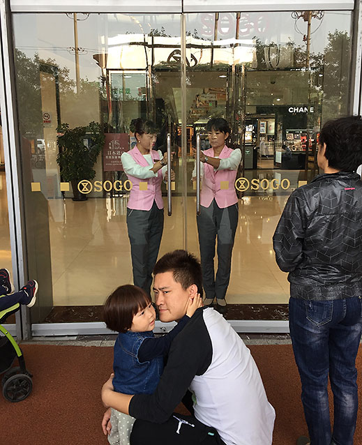 employees open the doors to a SOGO department store in Beijing