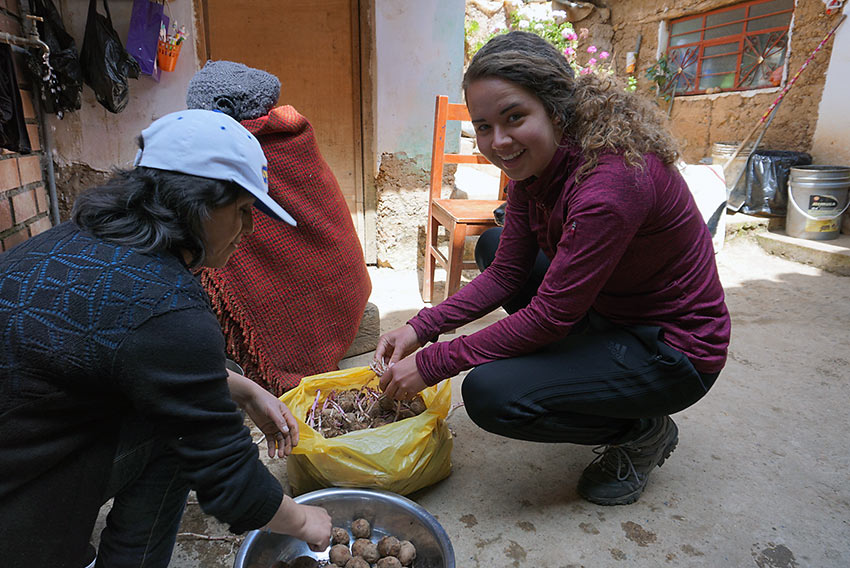 author's sister helping locals peel potatoes