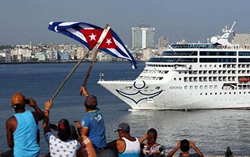 waving flags at an arriving cruise ship, Cuba