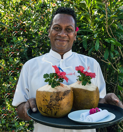 Bartender William Celua at Tides Reach with fresh coconuts