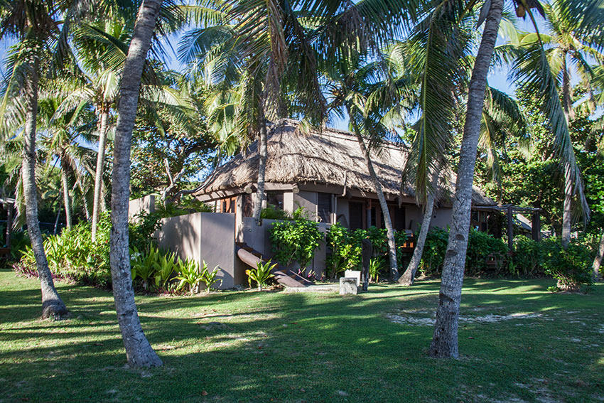 shade palms, green lawns and cottage at Yasawa Island Resort
