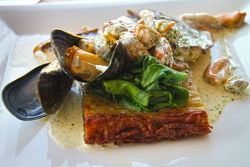 cockles and muscles served over potato cake