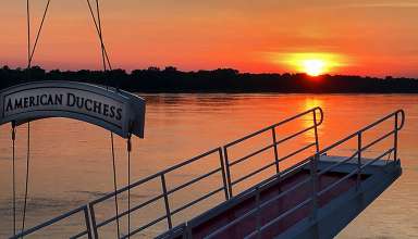 sunset on Mississippi River framed by a gangway on the American Duchess