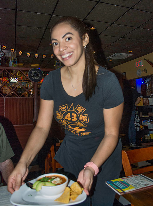 43 Casa employee serving a sizzling bowl of Mexico City style bean soup