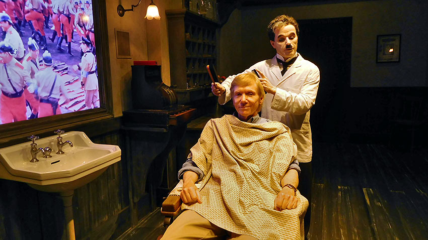 Charlie Chaplin barber recreator giving haircut at Chaplin's World