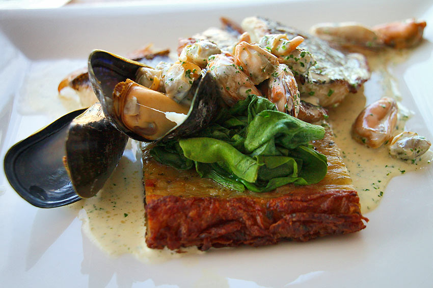 cockles and mussels served over potato cake