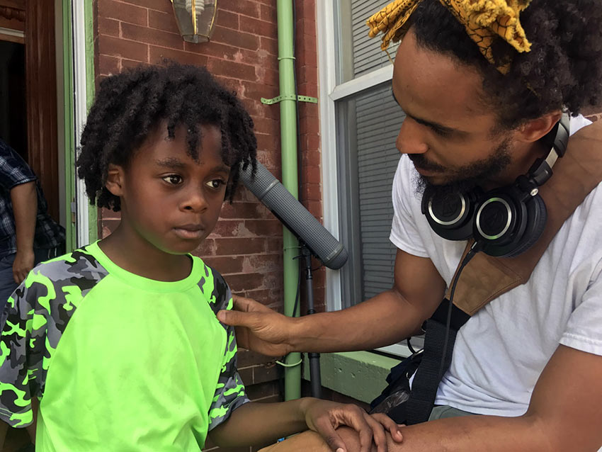 Jacari Dye as the “Young Jay” taking direction from filmmaker Merawi Gerima