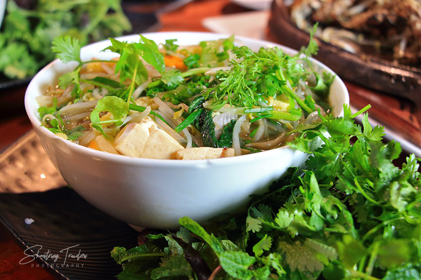 green vegetables and a bowl of pho