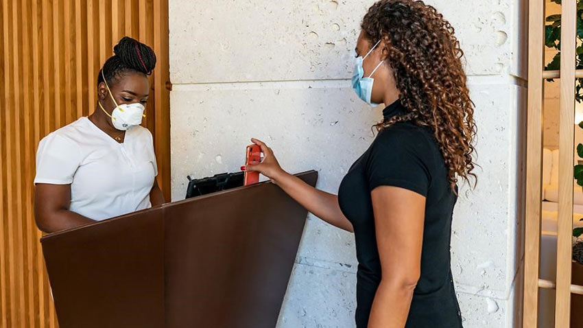 woman has her Covid health app checked at the Grand Hyatt Baha Mar