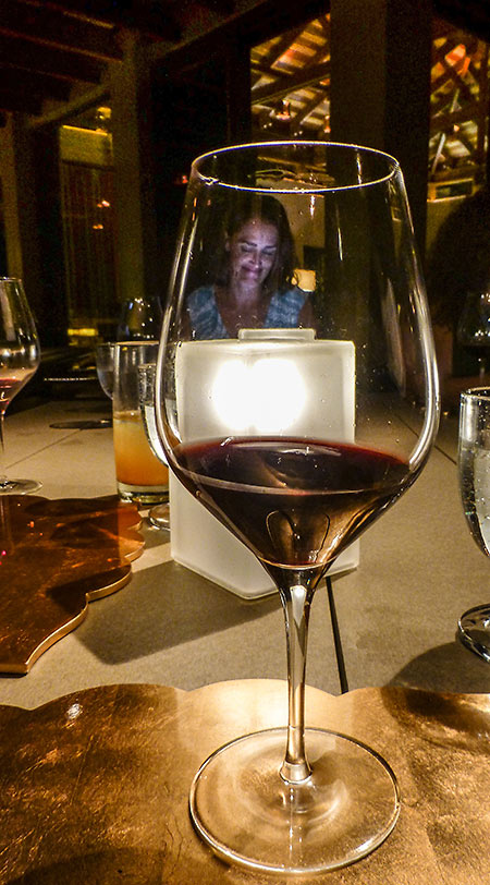 Villa Manager Jenifer Cowles, at dinner, seen through a glass of wine